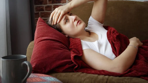 リビングのソファに横たわっ頭痛や片頭痛を持つ若い女性の肖像画 — ストック写真