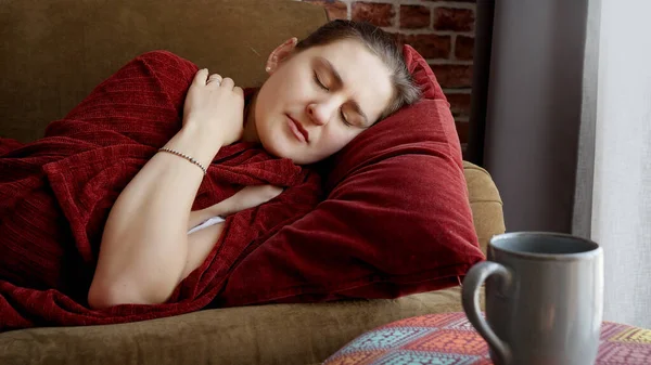 年轻的生病妇女穿着格子呢衣服躺在沙发上咳嗽 妇女在家中感到不适 疾病和健康问题 — 图库照片
