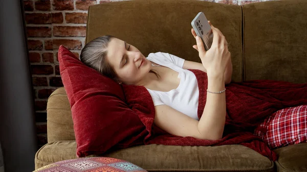 Mooie Vrouw Pyjama Liggend Bank Woonkamer Met Behulp Van Smartphone — Stockfoto