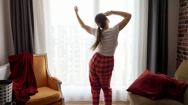 穿着睡衣的有趣女人在客厅的大窗户边跳舞 人们在家里放松 有乐趣 有积极的情绪 有乐趣 — 图库照片