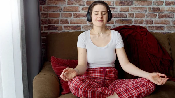 Mujer Joven Pijama Meditando Sofá Con Auriculares Concepto Relajación Estilo — Foto de Stock