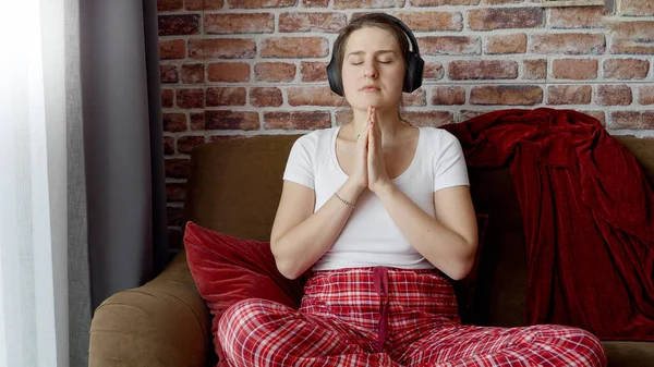 Mujer Joven Con Auriculares Meditando Sofá Sala Estar Concepto Relajación —  Fotos de Stock