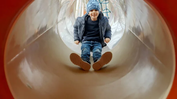 Netter Lächelnder Junge Der Unten Der Tunnelrutsche Auf Dem Spielplatz — Stockfoto