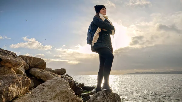 Sırt Çantalı Genç Bir Kadın Uçurumda Kaya Tepesinde Durup Soğuk — Stok fotoğraf
