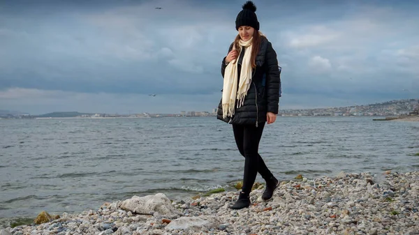 Leende Ung Kvinna Med Ryggsäck Som Utforskar Stenig Havsstrand Kallt — Stockfoto