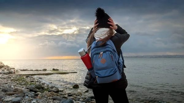 Young Woman Backpack Thermos Exploring Rugged Sea Coastline Cold Windy — Stock Photo, Image