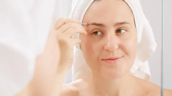 Leende Ung Kvinna Vit Handduk Plockar Ögonbrynen Med Kosmetiska Pincett — Stockfoto