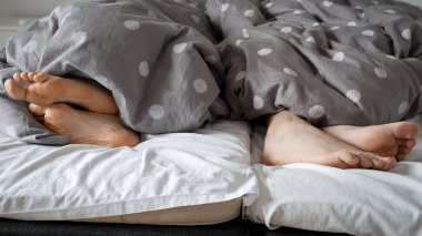 Çift ayaklarının yatakta yatıp birbirlerine arkasını dönmeleri. Aile içi çatışma, tartışma ve kötü ilişkiler kavramı