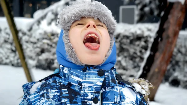Zabawny Chłopczyk Czapce Zimowej Katując Płatki Śniegu Językiem Parku Podczas — Zdjęcie stockowe