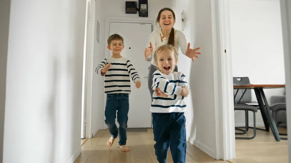 Twee Kleine Jongens Hun Moeder Rennen Lachen Thuis Houten Vloer — Stockfoto