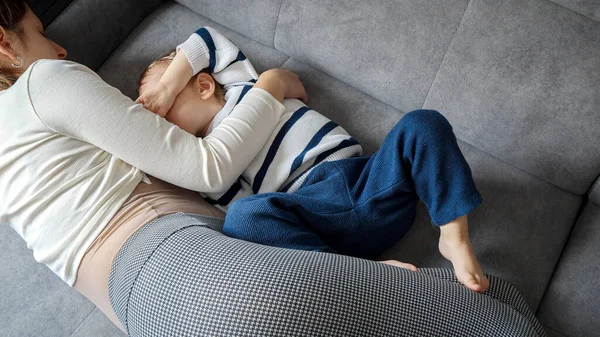 母親は 暖かさと快適さに囲まれたソファの上で赤ちゃんの息子を母乳で育てます 妊産婦のケア 子供の発達 母乳育児の重要性の概念 — ストック写真