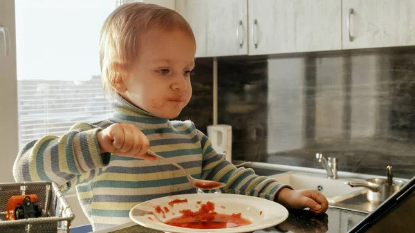 Carino Ragazzo Disordinato Mangiare Zuppa Con Cucchiaio Guardare Cartoni Animati — Foto Stock