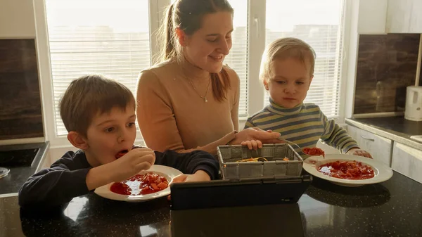 Νεαρή Μητέρα Ταΐζει Τους Γιους Της Σούπα Στην Κουζίνα Οικιακά — Φωτογραφία Αρχείου