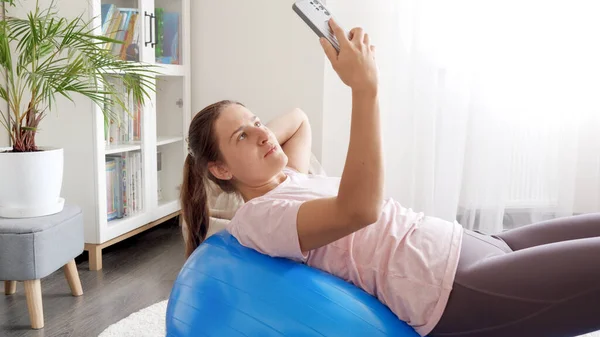 年轻的女性影响者在做健身运动的同时 在智能手机上录制视频 — 图库照片