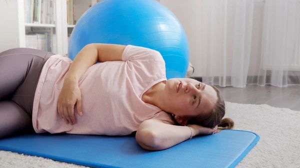 疲れ汗をかく女性はほとんど呼吸し フィットネスマットで板運動を行う前に休憩を持っています 自宅での医療 スポーツ ヨガの概念 — ストック写真