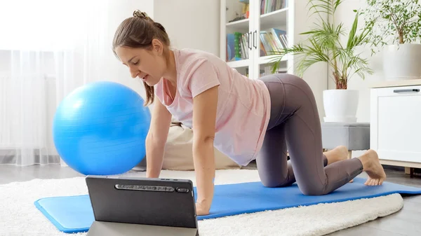 用平板电脑在家里健身的年轻女人 — 图库照片