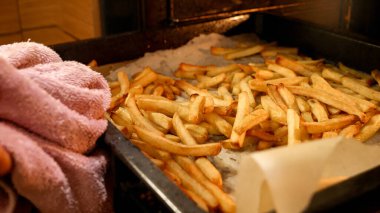 Patates kızartmasını fırından çıkarıp tavaya koymaya yakın çekim.