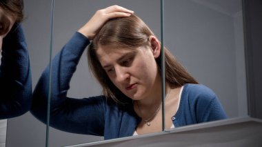 Aynaya bakarak sakinleşmeye çalışan kızgın kadının portresi. Depresyon, stres, zihinsel hastalık ve sorunlar, yalnızlık ve hüsran kavramı