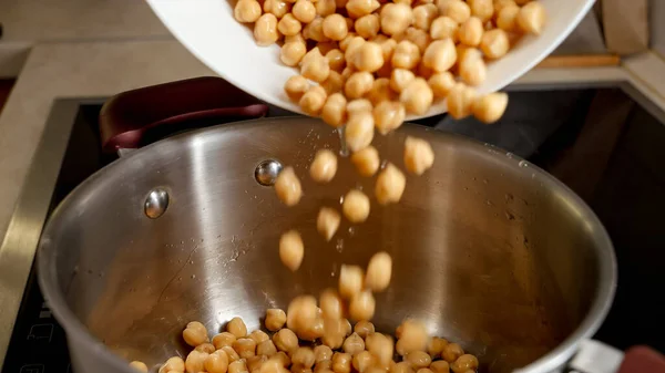水で鍋に浸したひよこ豆を注ぐのスローモーション マメ科植物 健康的な栄養 ビーガンフード — ストック写真