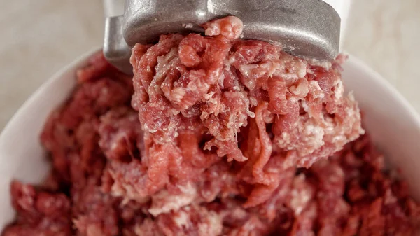 電気粉砕機から出てくるミンチ肉の閉まりとボウルに落ちる 家庭での調理 キッチン家電 健康的な栄養 ハンバーガーの成分 — ストック写真