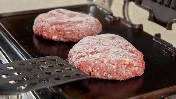 将冷冻汉堡包牛肉片放在热烤架上的手部闭锁 家庭烹调 厨房用具 健康营养 汉堡包配料 — 图库照片