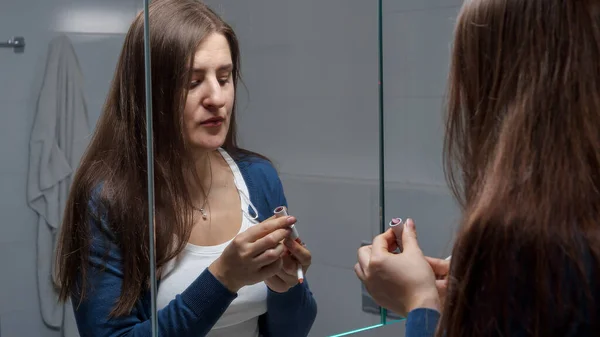 Vacker Ung Kvinna Tillämpa Rött Läppstift Badrummet Medan Tittar Spegeln — Stockfoto