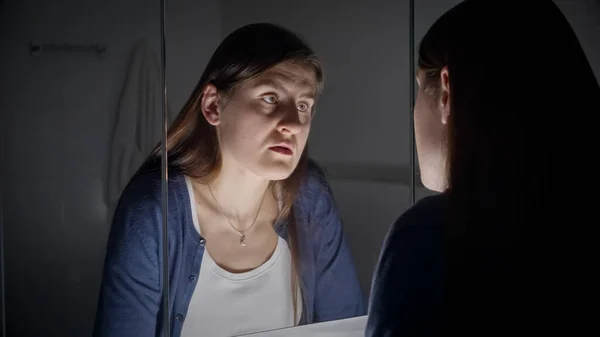 stock image Upset and tired woman looking at her reflection in mirror. Concept of depression, suicide, stress, mental illness, loneliness and frustration