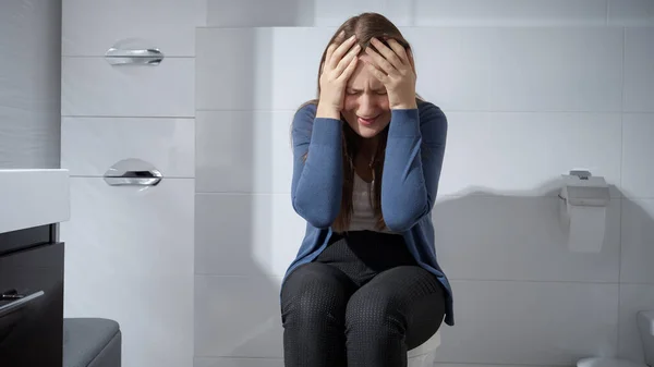 若い動揺した女性だけでトイレに座って泣いている うつ病 家庭内暴力 ストレス フラストレーションの概念 — ストック写真