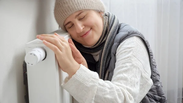 Νεαρή Γυναίκα Χειμωνιάτικα Ρούχα Αισθάνεται Κρύο Αγκαλιάζει Θερμαντήρα Ψυγείο — Φωτογραφία Αρχείου