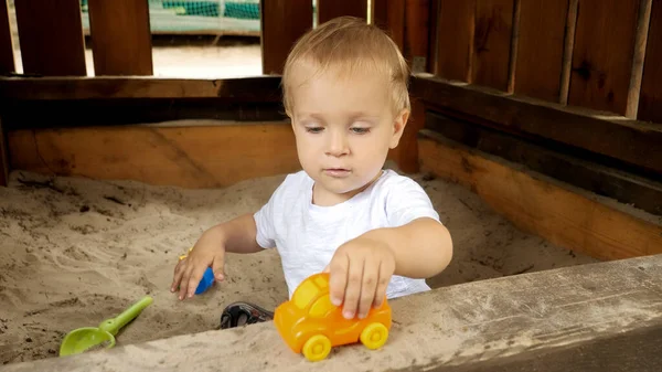 Parktaki Kum Havuzunda Renkli Oyuncaklar Arabalarla Oynayan Küçük Bir Çocuk — Stok fotoğraf