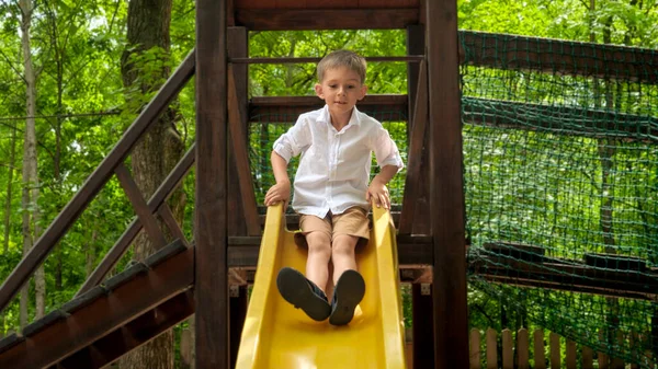 Mały Chłopiec Jadący Zjeżdżalnią Letnim Parku Przygód Dzieci Bawiące Się — Zdjęcie stockowe