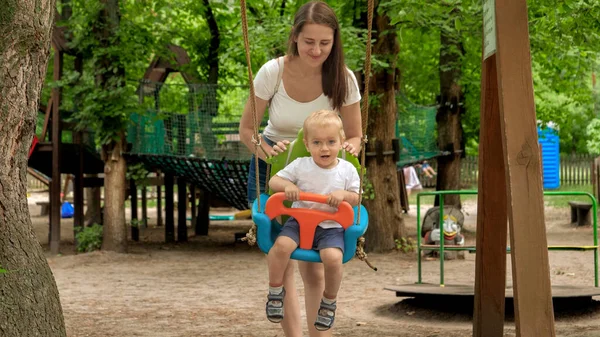 Smiling Mother Pushing Her Baby Son Swinging Playground Kids Playing — Stock Photo, Image