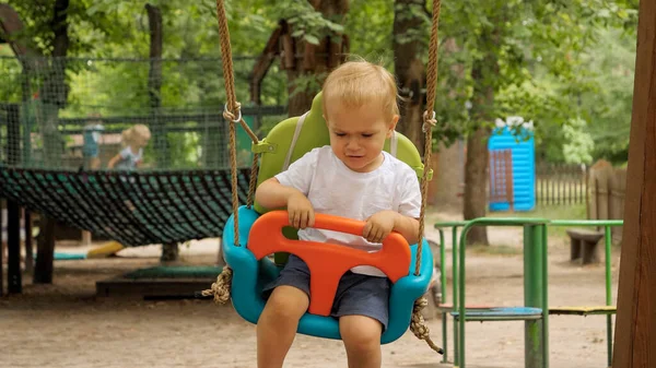 Porträtt Liten Olycklig Pojke Som Svänger Färgglad Gunga Parken Barn — Stockfoto
