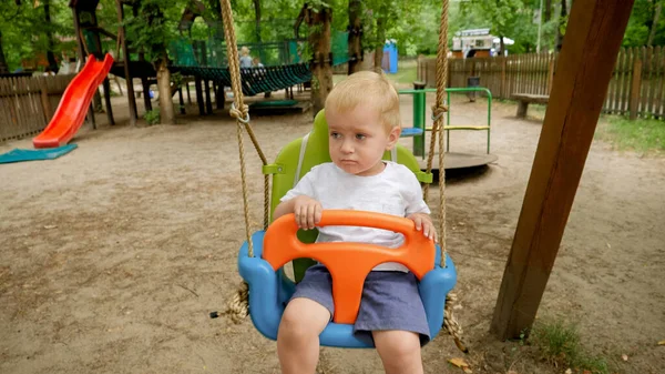 Zbliżenie Uroczy Chłopiec Siedzi Huśtawka Kolorowe Huśtawka Parku Dzieci Bawiące — Zdjęcie stockowe