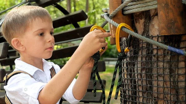Kleiner Junge Klemmt Sicherheitshaken Seil Bevor Abenteuerpark Auf Baum Klettert — Stockfoto