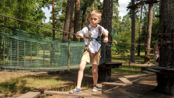 Boy Holding Rope While Walking Wobbly Wooden Bridge Outdoor Adventure — Stock Photo, Image