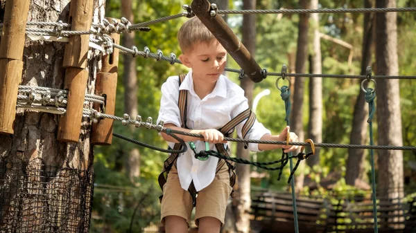 アドベンチャーパークで子供クライミングや金属フック付きの安全ロープをフック アクティブな子供時代 健康的なライフスタイル 屋外で遊んでいる子供 自然の中で子供 — ストック写真