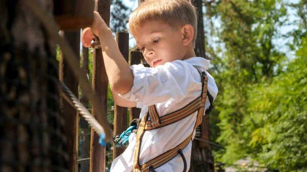 Portret Małego Trzymającego Mocno Linę Podczas Wspinaczki Przeszkodach Parku Przygód — Zdjęcie stockowe