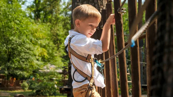 Portret Młodego Chłopca Wspinającego Się Przecinającego Most Linowy Drewnianymi Deskami — Zdjęcie stockowe