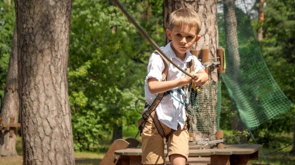 在户外冒险公园 一个小男孩在树间的绳子上行走的画像 活跃的童年 健康的生活方式 户外玩耍的孩子 大自然中的孩子 — 图库照片