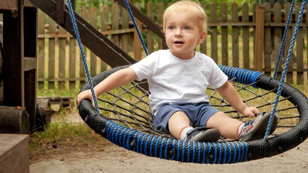 Menino Divertindo Sorrindo Enquanto Cavalgava Ninho Corda Balançando Parque Crianças — Fotografia de Stock