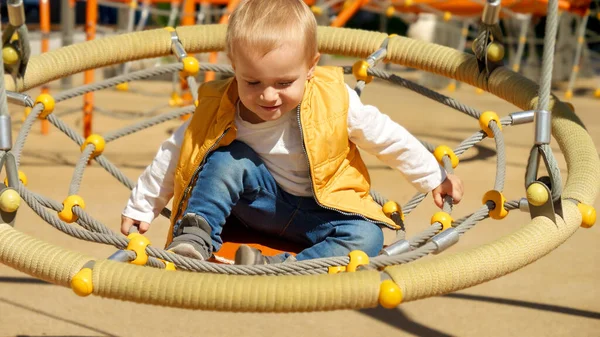 Cute Chłopiec Siedzi Okrągłym Huśtawce Zabawy Placu Zabaw Dzieci Bawiące — Zdjęcie stockowe