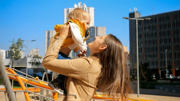 Šťastná Veselá Žena Vyhazuje Svého Malého Syna Vzduchu Proti Modré — Stock fotografie