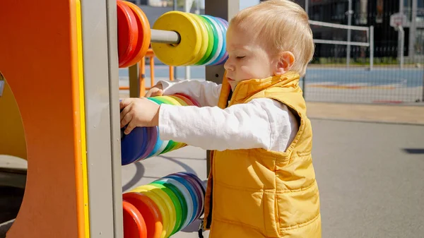 Portret Koktajlowego Chłopca Bawiącego Się Kolorową Drewnianą Obfitością Placu Zabaw — Zdjęcie stockowe