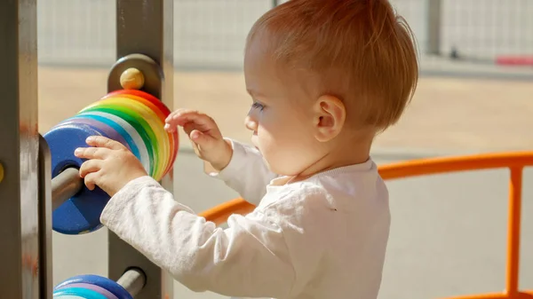 一个小男孩在操场上的算盘上旋转着五彩斑斓的圆圈的画像 儿童发展 儿童教育 婴儿学习 — 图库照片