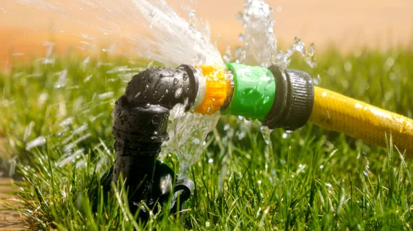 Water droplet leaking through damaged garden hose and pipe. Water waste, garden equipment, gardening