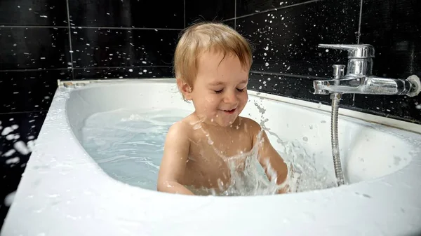 赤ん坊の男の子は彼の浴室の時間を楽しみ 泡およびスポンジと遊ぶ 赤ちゃんの衛生ルーチンに欠かせない入浴時間の重要性を強調しています — ストック写真