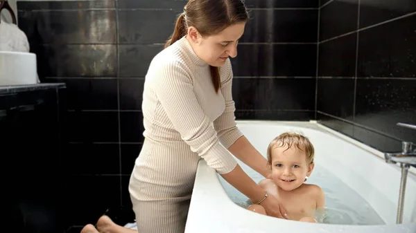Lindo Niño Sonriente Sentado Baño Mientras Madre Cariñosa Está Lavando — Foto de Stock