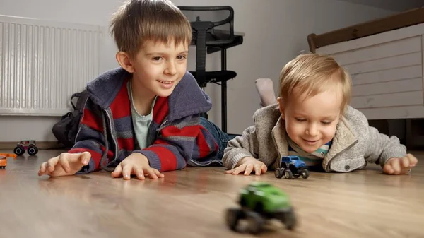 바닥에 장난감 자동차 경주를 아이들은 혼자놀고 교육을 집에서 게임을 합니다 — 스톡 사진