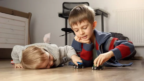 Dva Bratři Ležící Podlaze Hrající Barevnými Autíčky Děti Hrají Samy — Stock fotografie